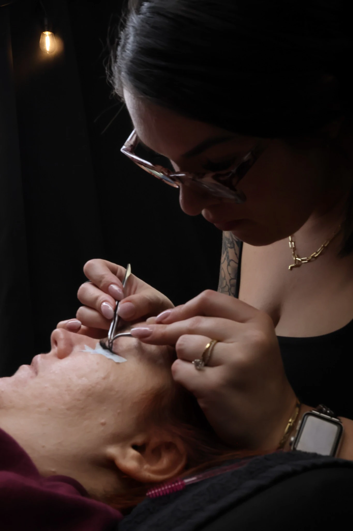 Jennifer applying lash extensions to a client at Blink & Slay Beauty.